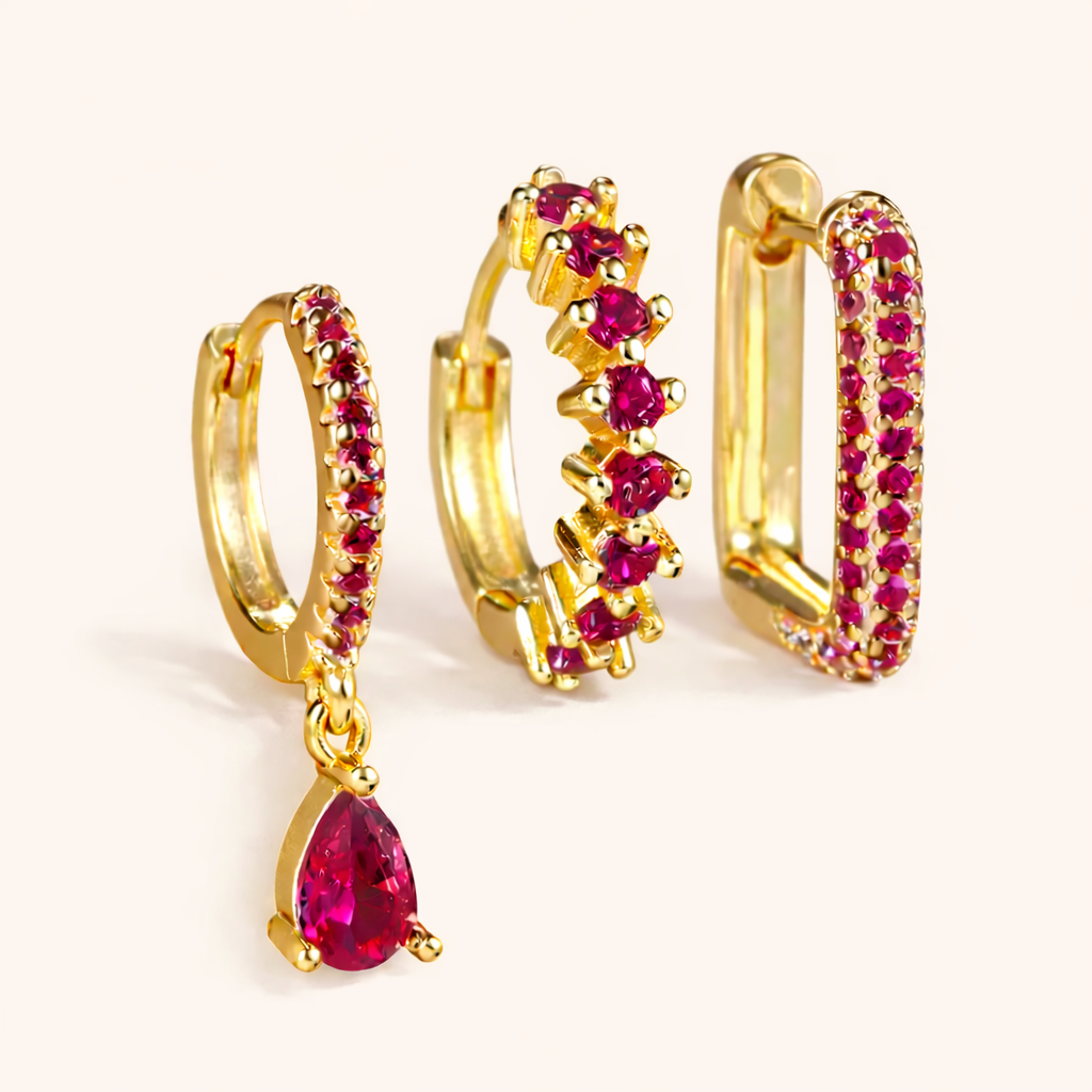The Fia SET is shown in a pink crystal colorway across its drop huggie, zigzag hoop, and pave rectangle hoop.