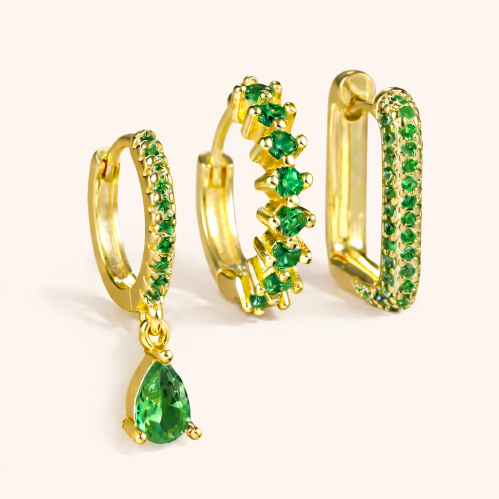 The Fia SET is shown in a green crystal colorway across its drop huggie, zigzag hoop, and pave rectangle hoop.