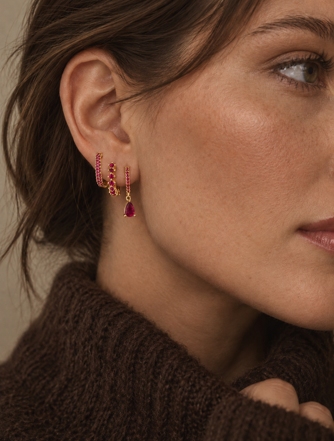 Model wears the Folie à Trois Fia SET in a ruby colorway, three gold hoops and a pear-cut ruby drop stacked along the ear.