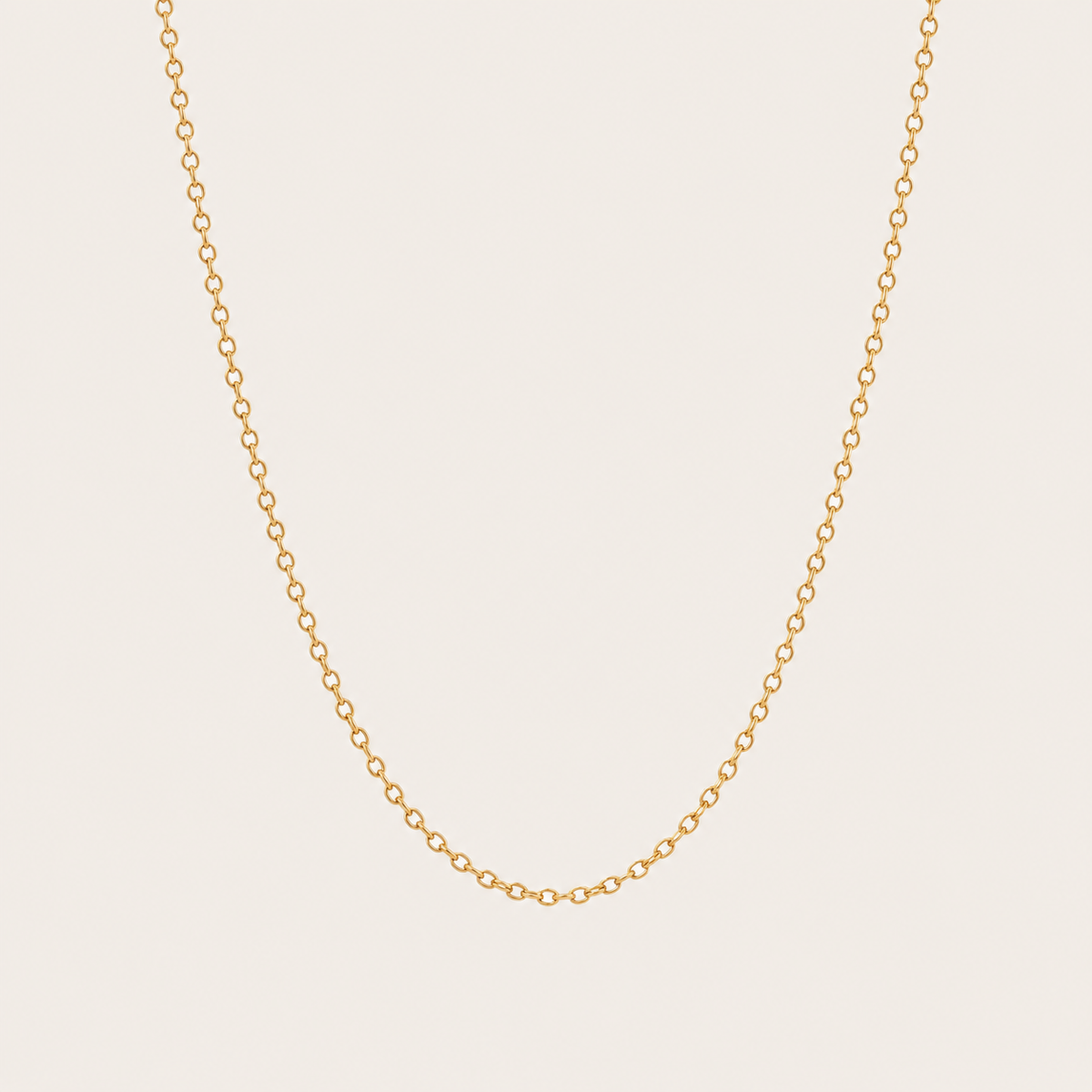 Gold cable-link chain necklace from the Filo NECKLACE design, photographed in close-up studio detail on a soft beige background.