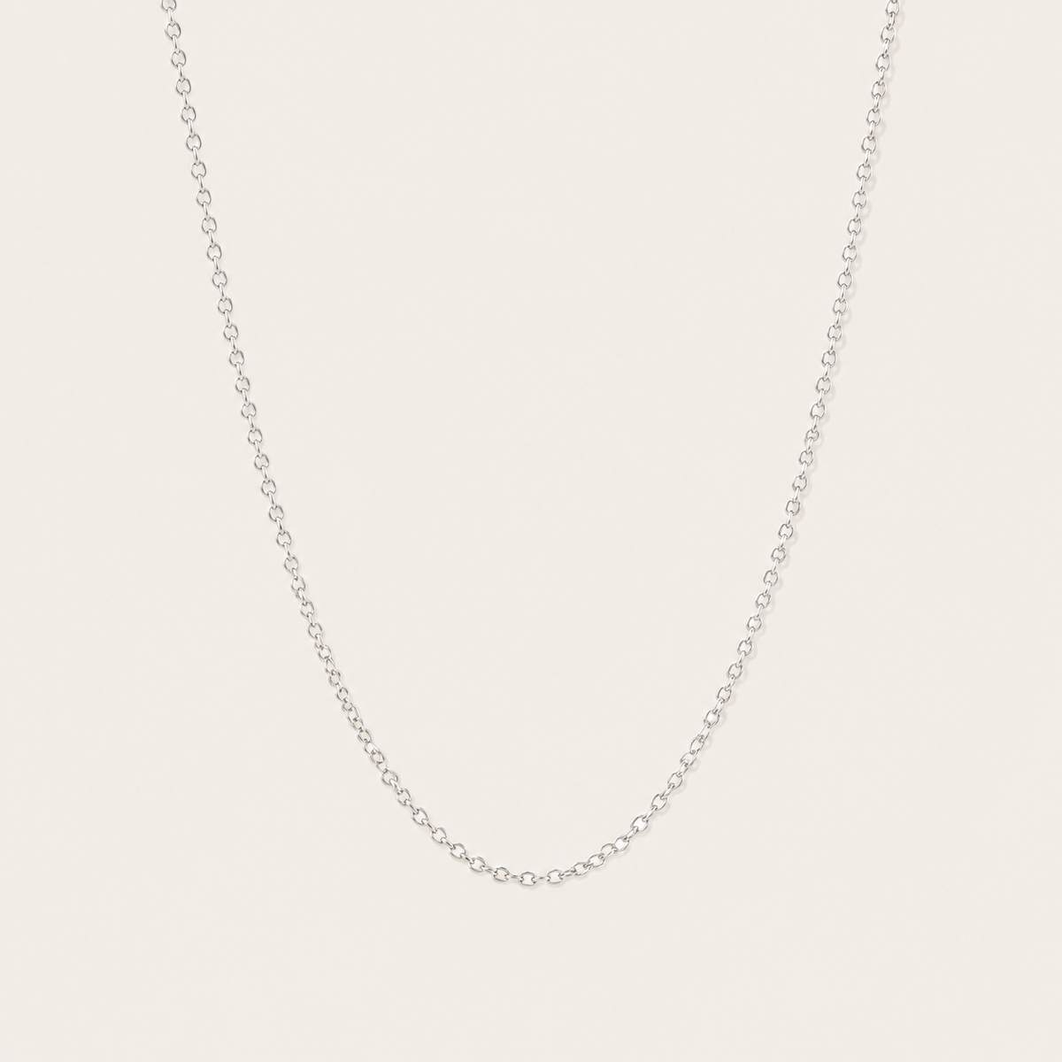 Silver cable-link chain necklace from the Filo NECKLACE design, shown in close-up studio detail on a soft beige background.