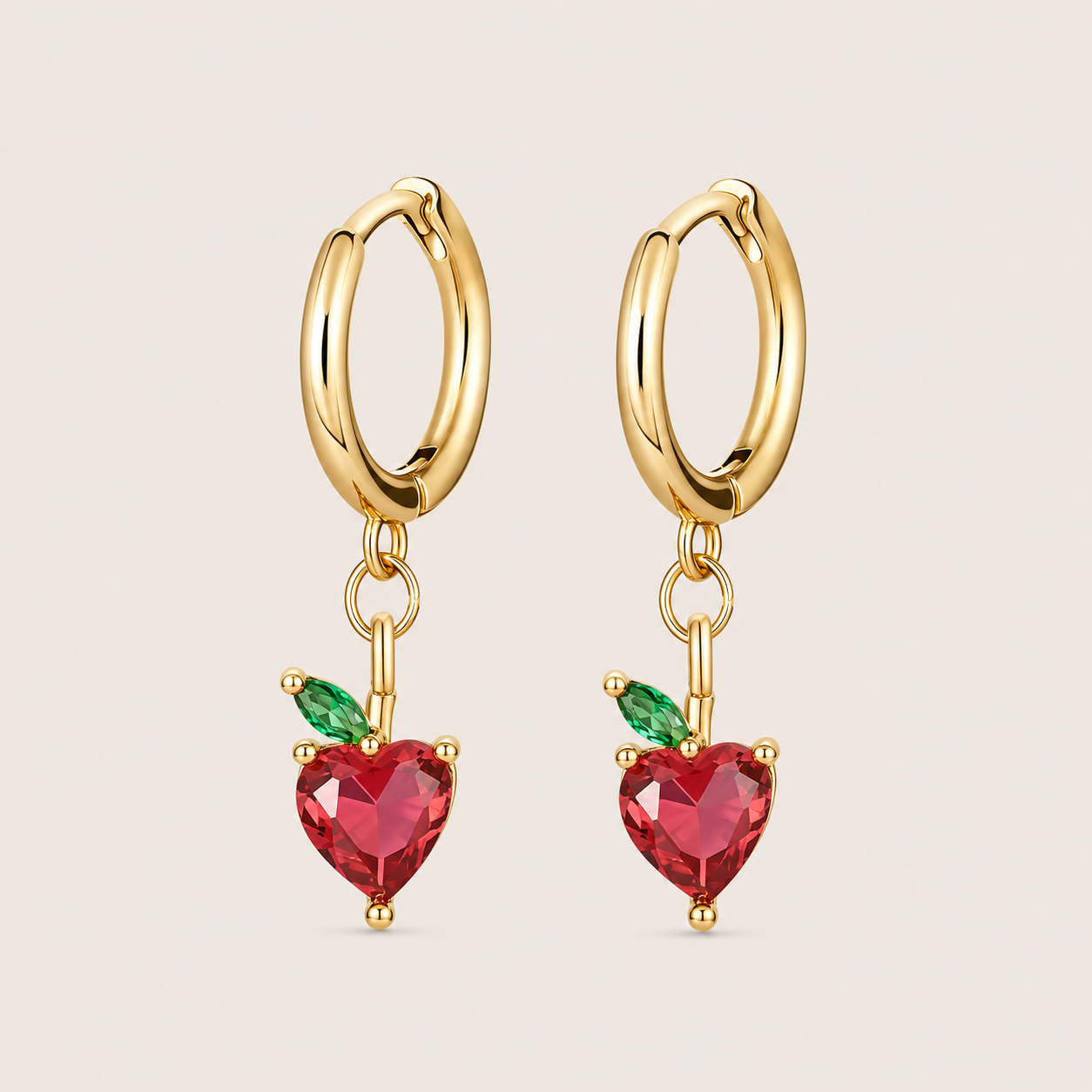 Gold hoop earrings from the Fruit Hoop EARRINGS with an apple-shaped charm in a deep red heart-cut stone and a green marquise leaf.