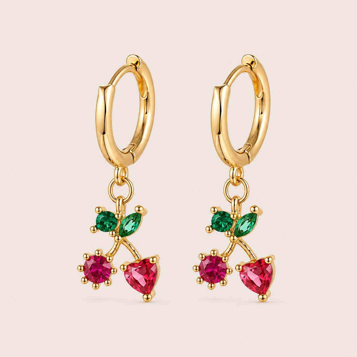 Gold hoop earrings from the Fruit Hoop EARRINGS with a cherry-pair charm of two pink-red stones and crossed green marquise leaves.