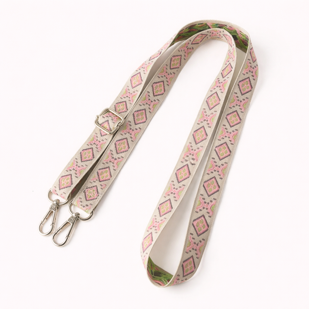 Woven Getaway long phone strap in cream and pink diamond pattern, coiled flat with silver clasps.