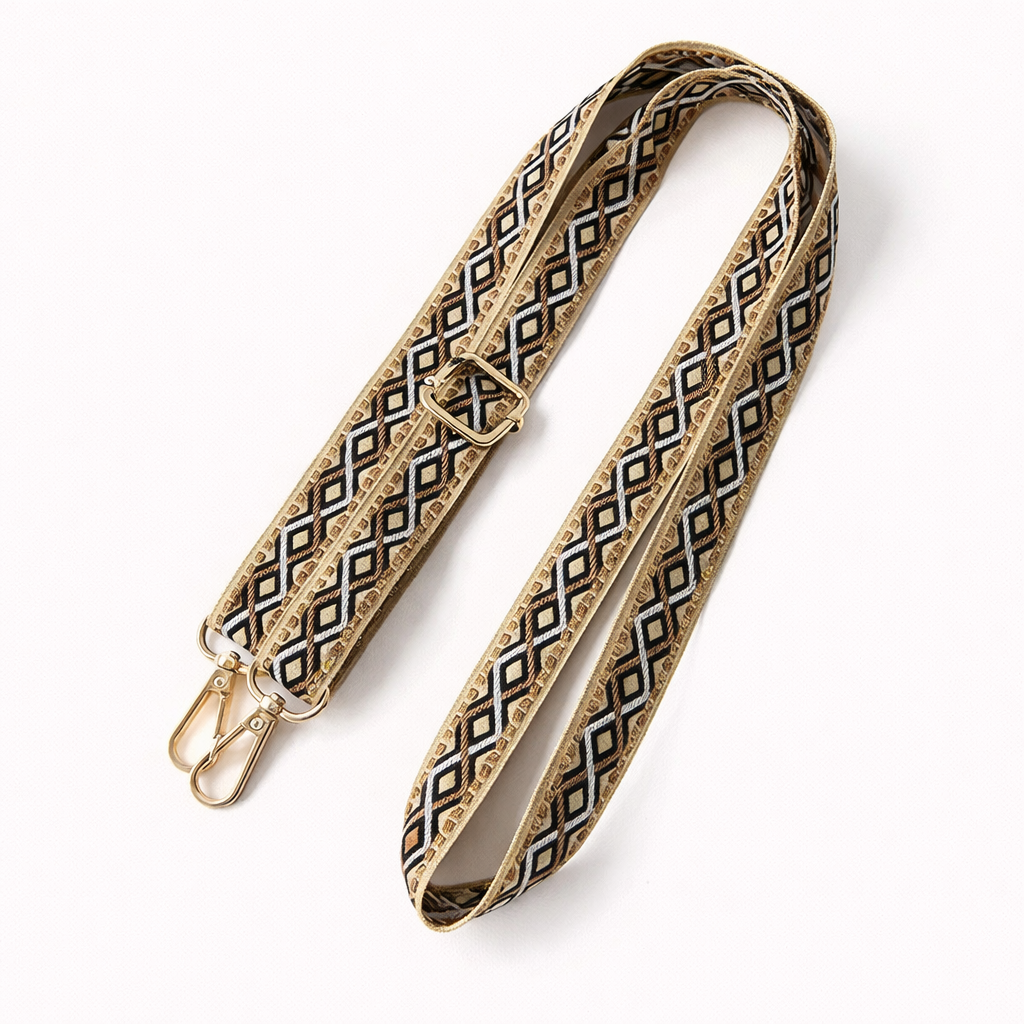 Woven Getaway long phone strap in tan, black, and white diamond pattern, coiled flat with gold clasps.