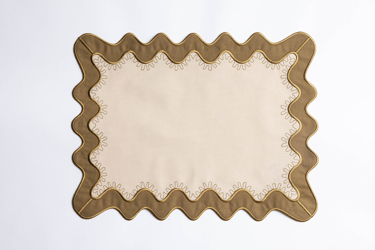 Olive-green scalloped placemat with a cream center and gold-stitched trim, the Gisèle Scallop placemat with embroidered detail.