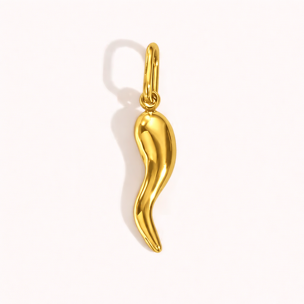 The Gold Chili Pepper CHARM in a studio flat lay, a curved polished gold pendant in a chili pepper silhouette on a cream background.