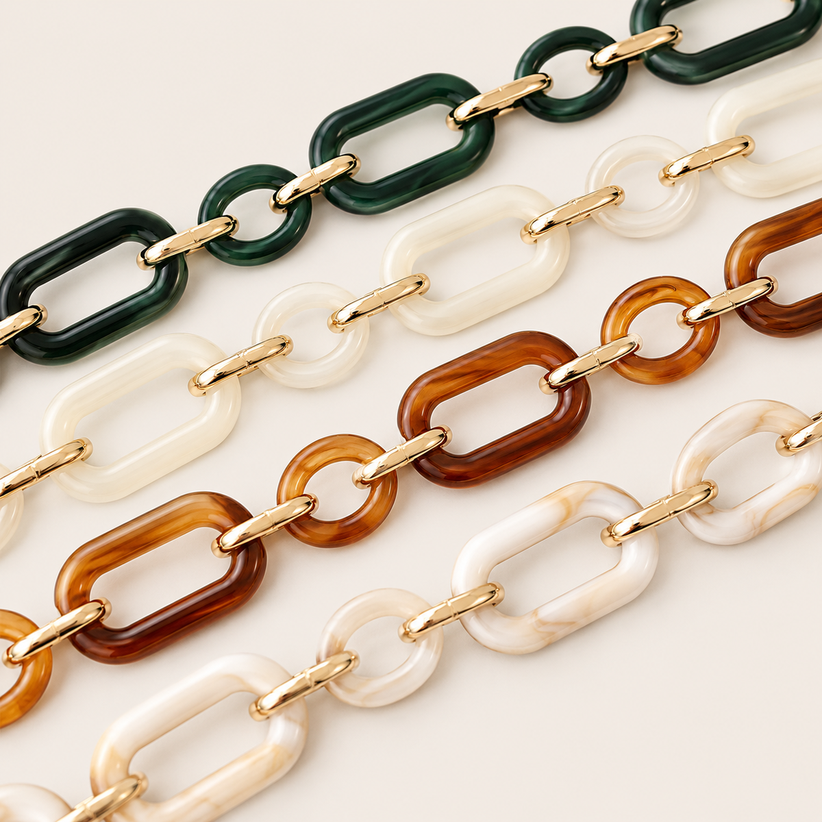 Close-up of Hazel LONG PHONE CHAIN links in green, ivory, amber, and marbled acrylic colourways joined by gold-tone rings.