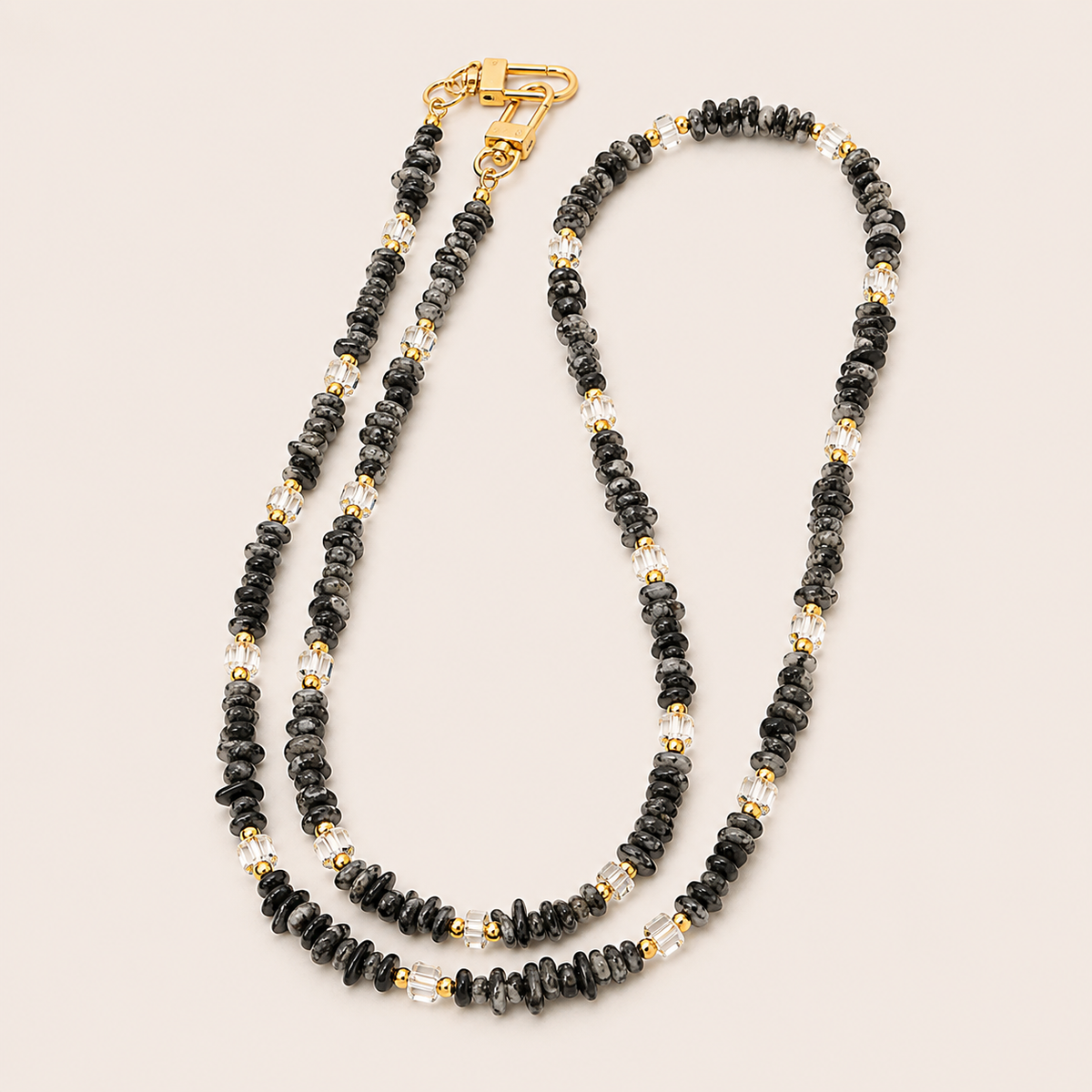 Double-strand black speckled and faceted clear bead phone chain with gold accents on cream — Folie à Trois Hollis long phone chain
