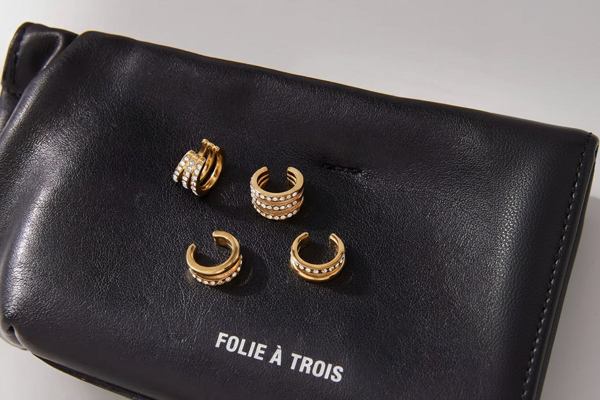 Hotline Ear Cuffs shown with the Wildcard cuffs on a black Folie a Trois pouch, highlighting the double-band and pave crystal designs.