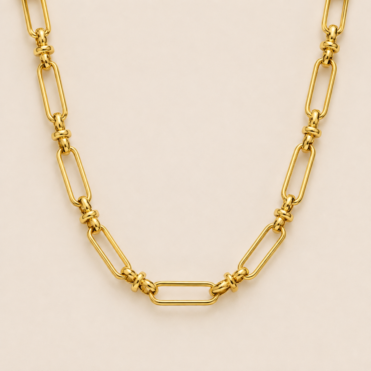 Gold paperclip-link chain necklace, the Iris NECKLACE, featuring elongated oval links joined by small round connectors, shown in close-up.