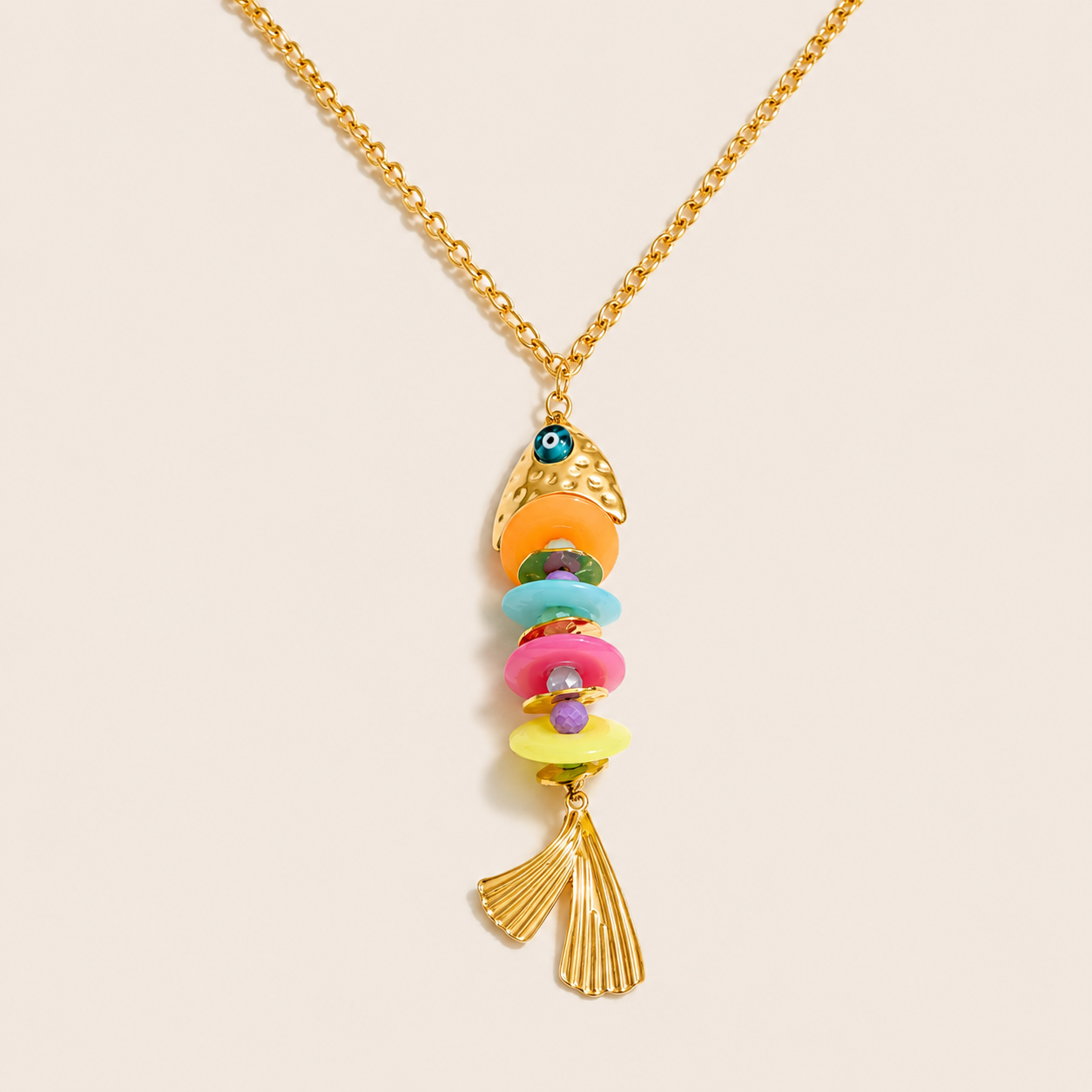 Gold Isla Bonita NECKLACE with a fish-shaped pendant of stacked colorful discs and a fanned gold tail, laid flat.
