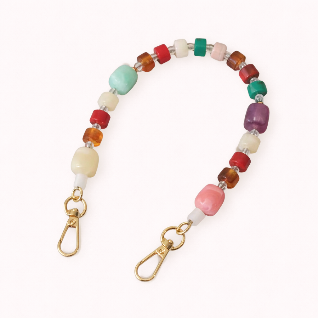 The Jaqueline PHONE STRAP in an amber tortoiseshell-effect chunky link chain with gold-tone clasps at both ends.