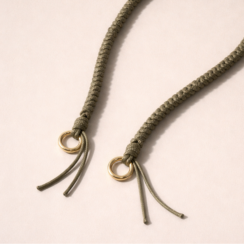 Olive green braided Layover long phone strap, close-up of the knotted gold ring and fringe end.