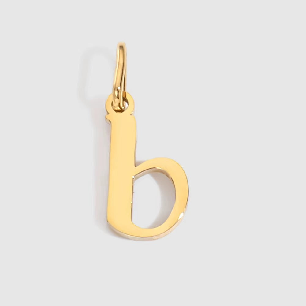 The Letter CHARM in lowercase b, a polished gold pendant in a serif b shape, shown in close-up on a light grey background.
