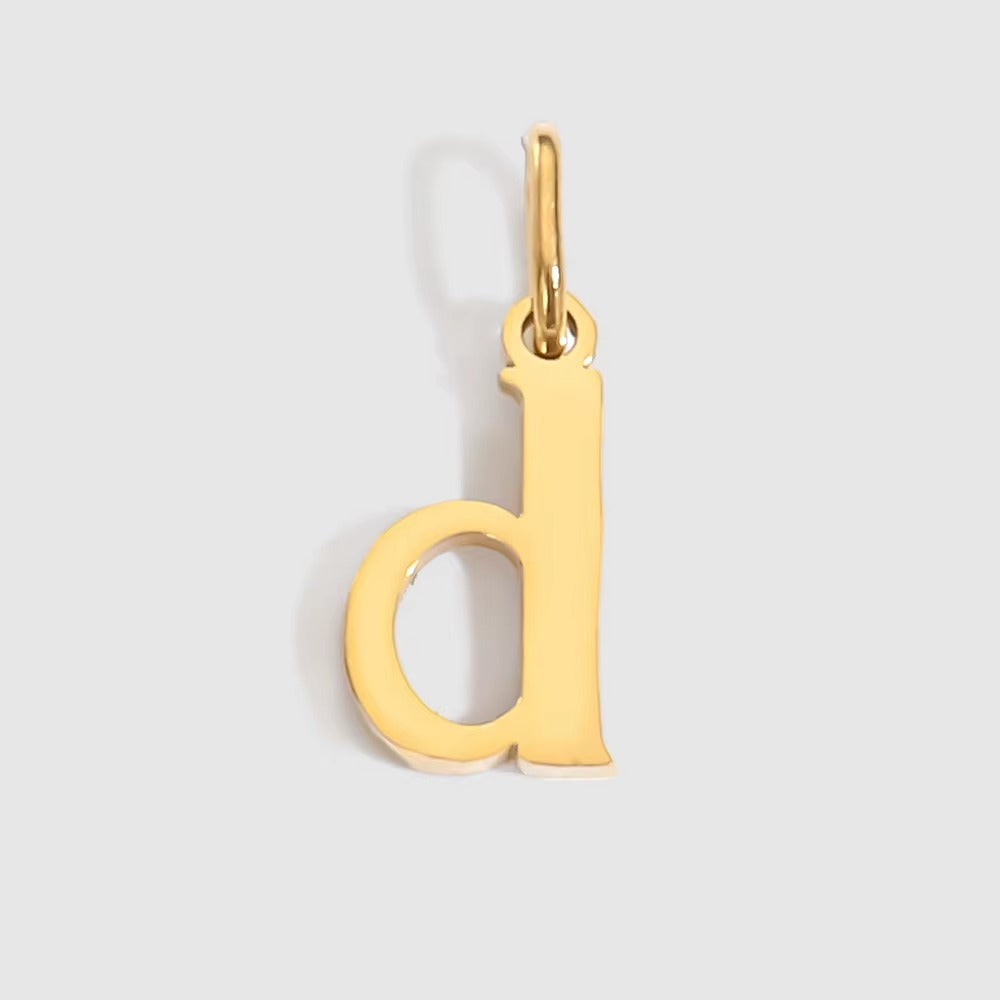 The Letter CHARM in lowercase d, a polished gold pendant in a serif d shape, shown in close-up on a light grey background.