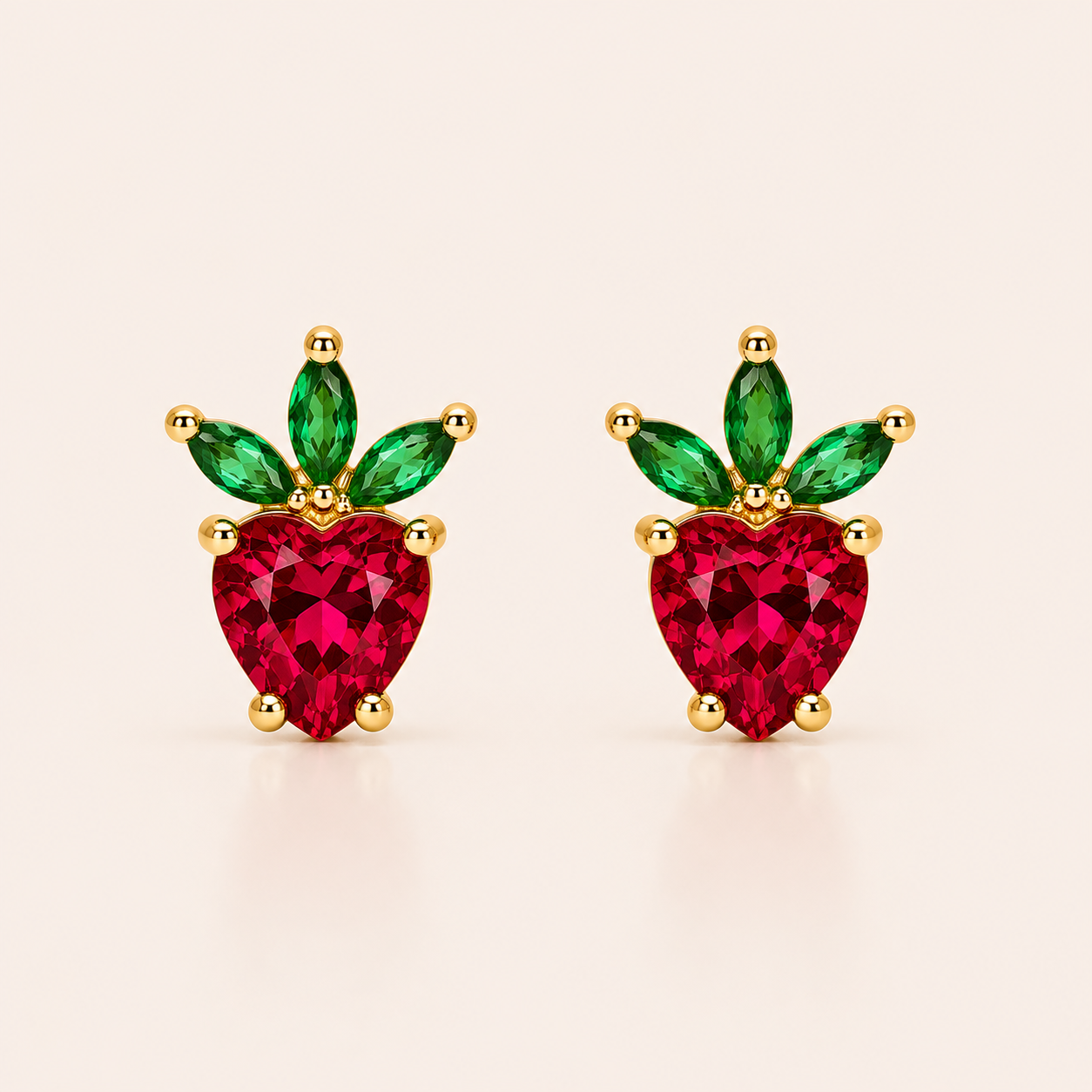 Gold strawberry-shaped stud earrings from the Little Fruit EARRINGS with a red heart-cut cubic zirconia and green marquise leaves.