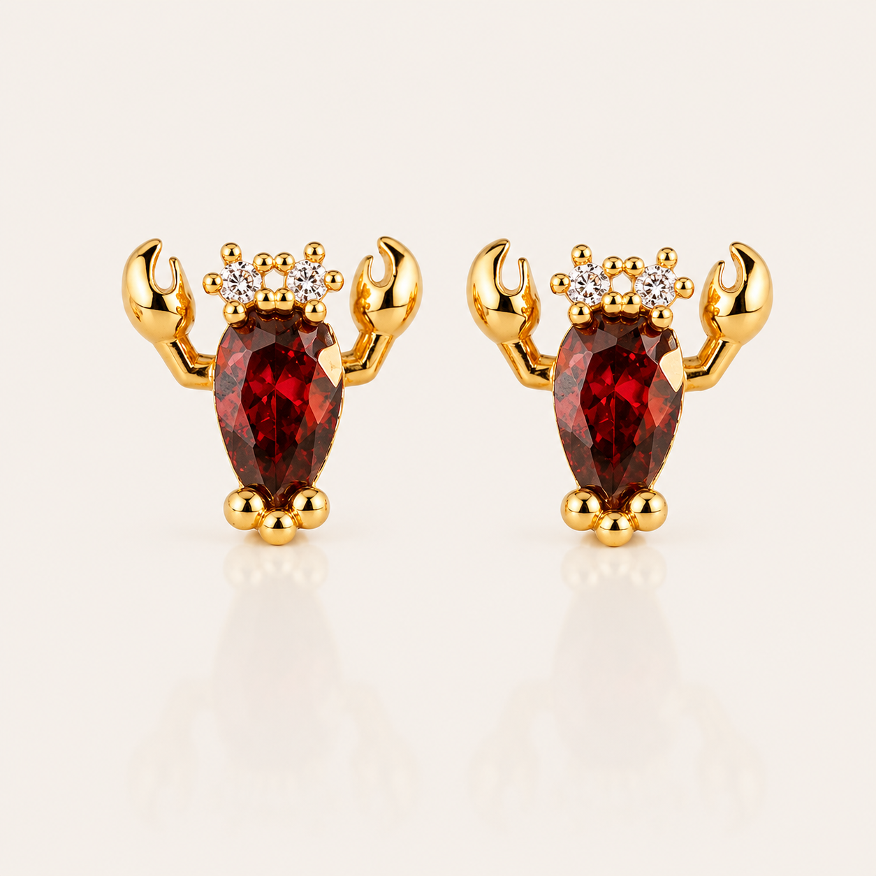 Gold Little Lobster EARRINGS stud with a red pear-cut cubic zirconia body, two curved claws, and three small white round accent stones.
