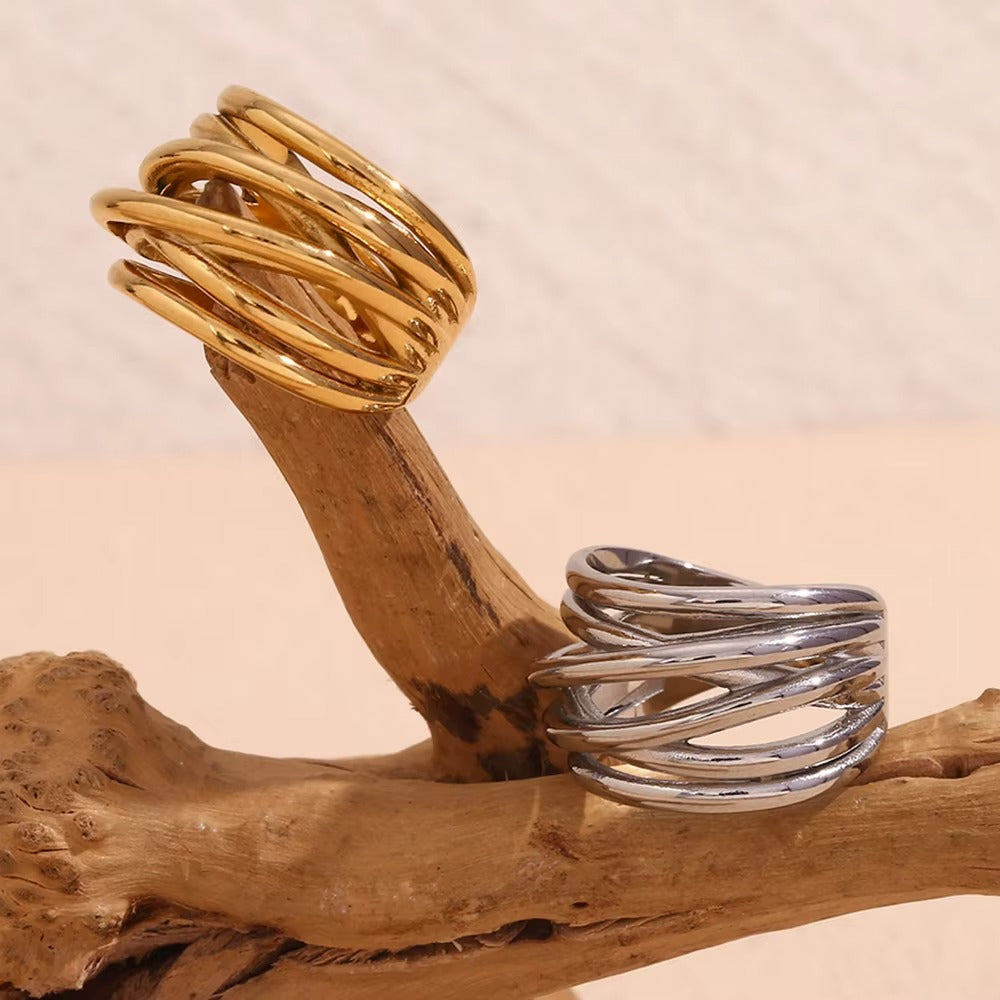 Gold and silver wide wrap-style Lizie RING pieces displayed side by side on a weathered driftwood branch.