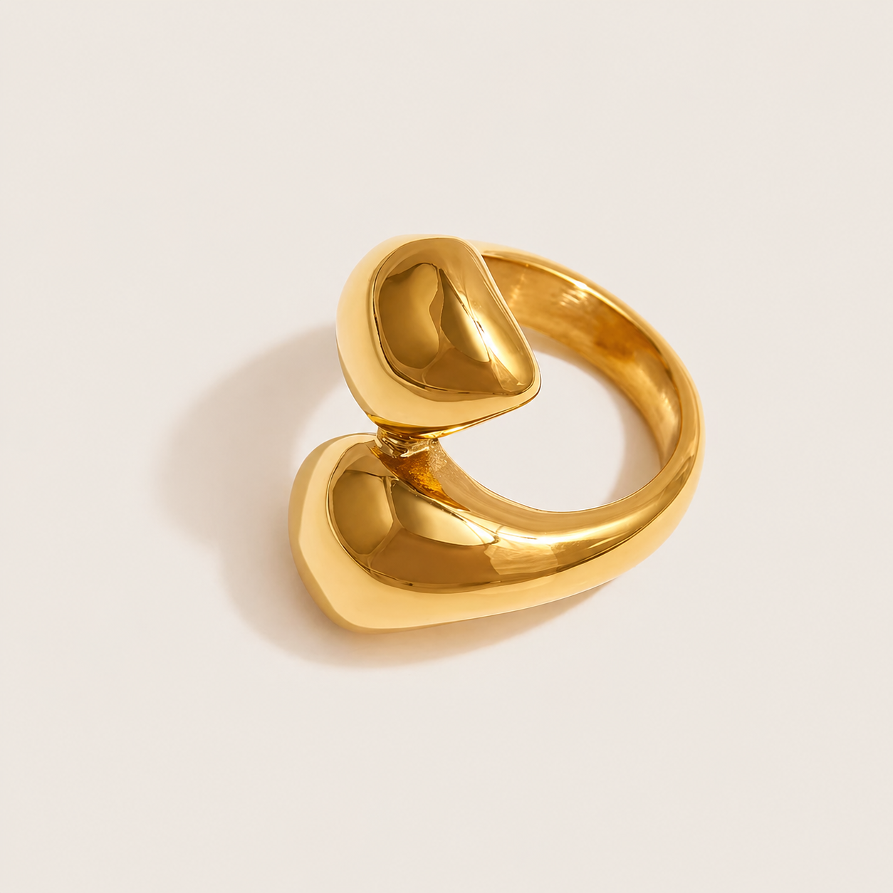 Gold ring with two overlapping polished pebble-shaped domes forming a wrap design, on a cream backdrop — Folie à Trois Lunaire RING.
