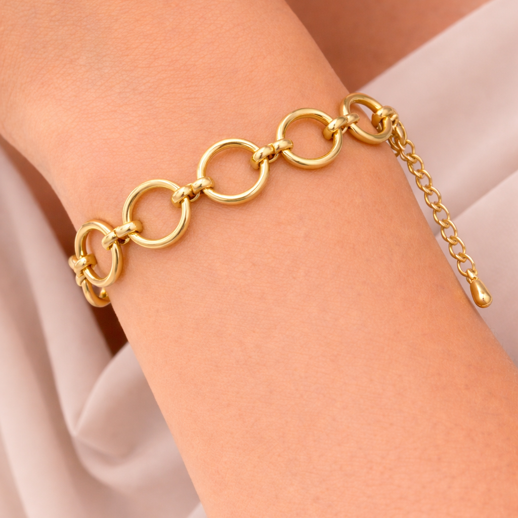 Main Character BRACELET worn on the wrist, close-up of the gold circle-link chain against a light blush sleeve.