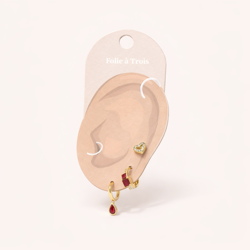 Displayed on a Folie a Trois ear card, Maisie SET appears in ruby red with a pave heart stud completing the layered look.
