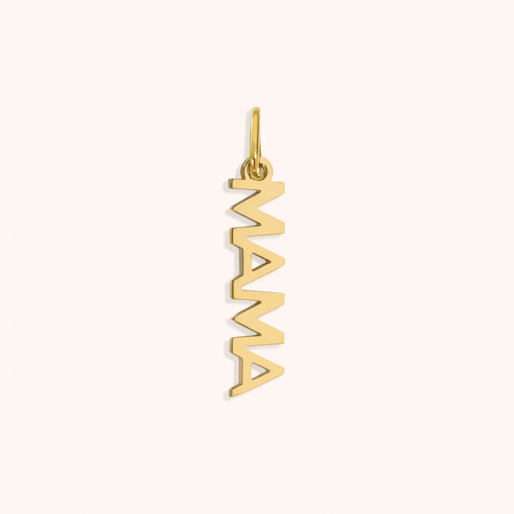 The Mama CHARM in a studio flat lay, a polished gold vertical script pendant reading MAMA on a cream background.