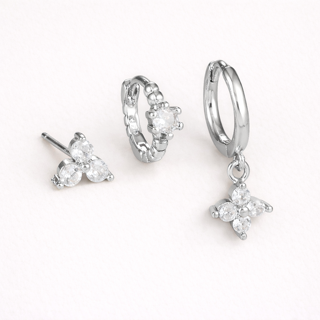 Manon Set in silver tone, a trio-stone stud, a beaded pave hoop, and a hoop with a dangling four-point crystal charm.