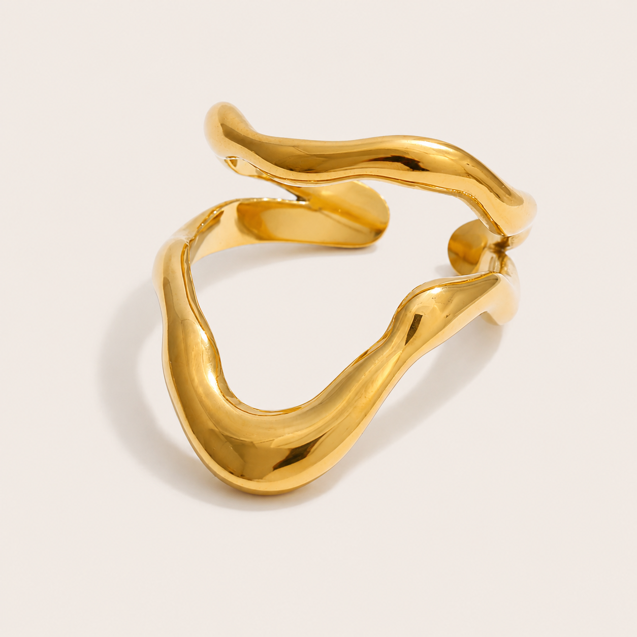 Gold open ring with a fluid, pointed V-shaped double loop, shown in close-up on a cream backdrop — Folie à Trois Mare & Soleil RING.