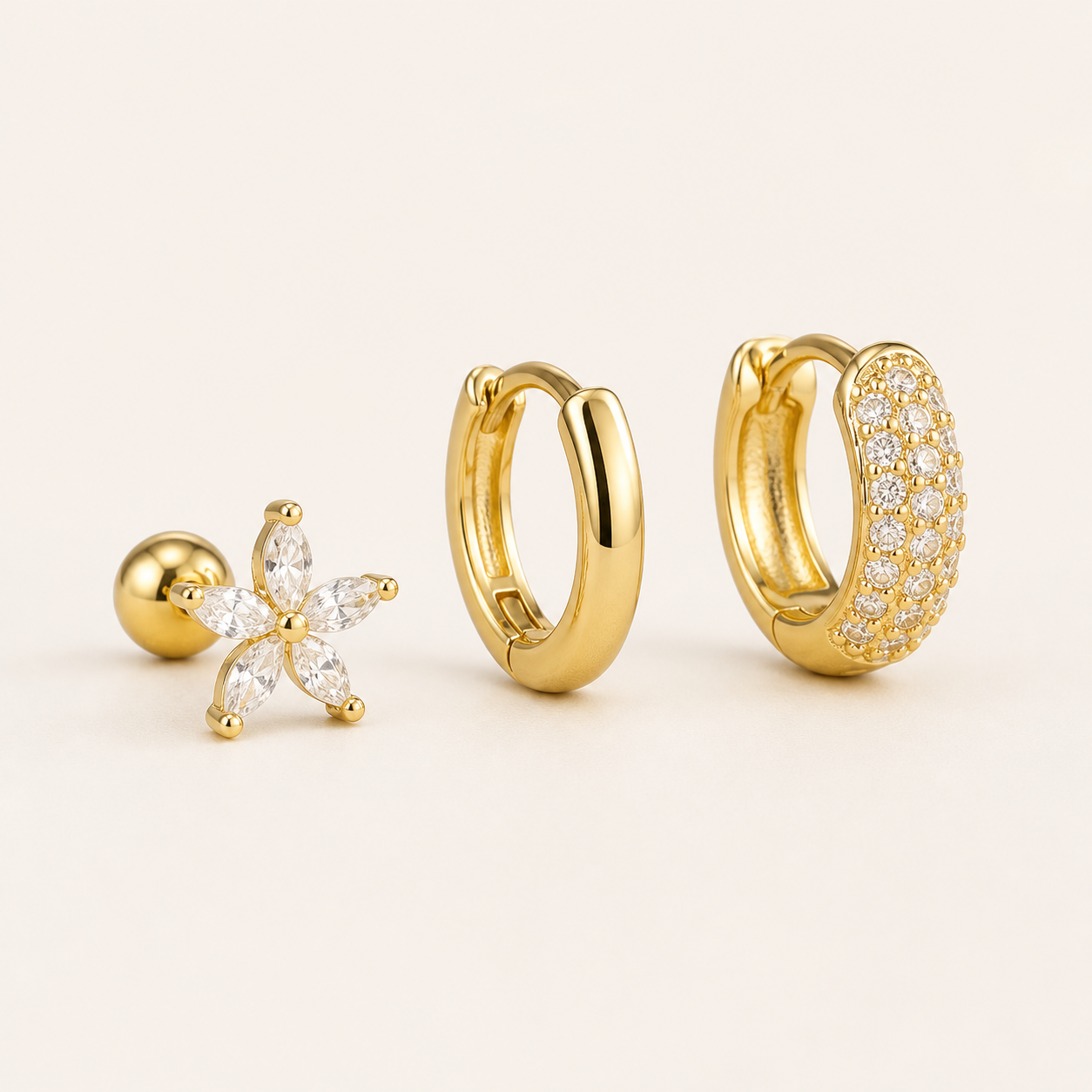 Three-piece Marigold SET gold earrings in clear stones: a flower stud, a plain hoop, and a pave hoop.