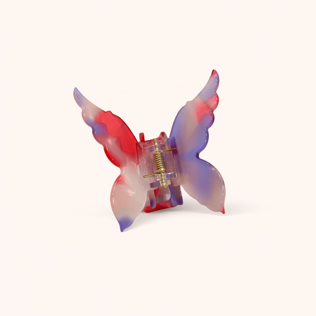 Red, blue and white ombré acetate butterfly-shaped claw clip from the Mariposa HAIR CLIP collection, on a cream background.