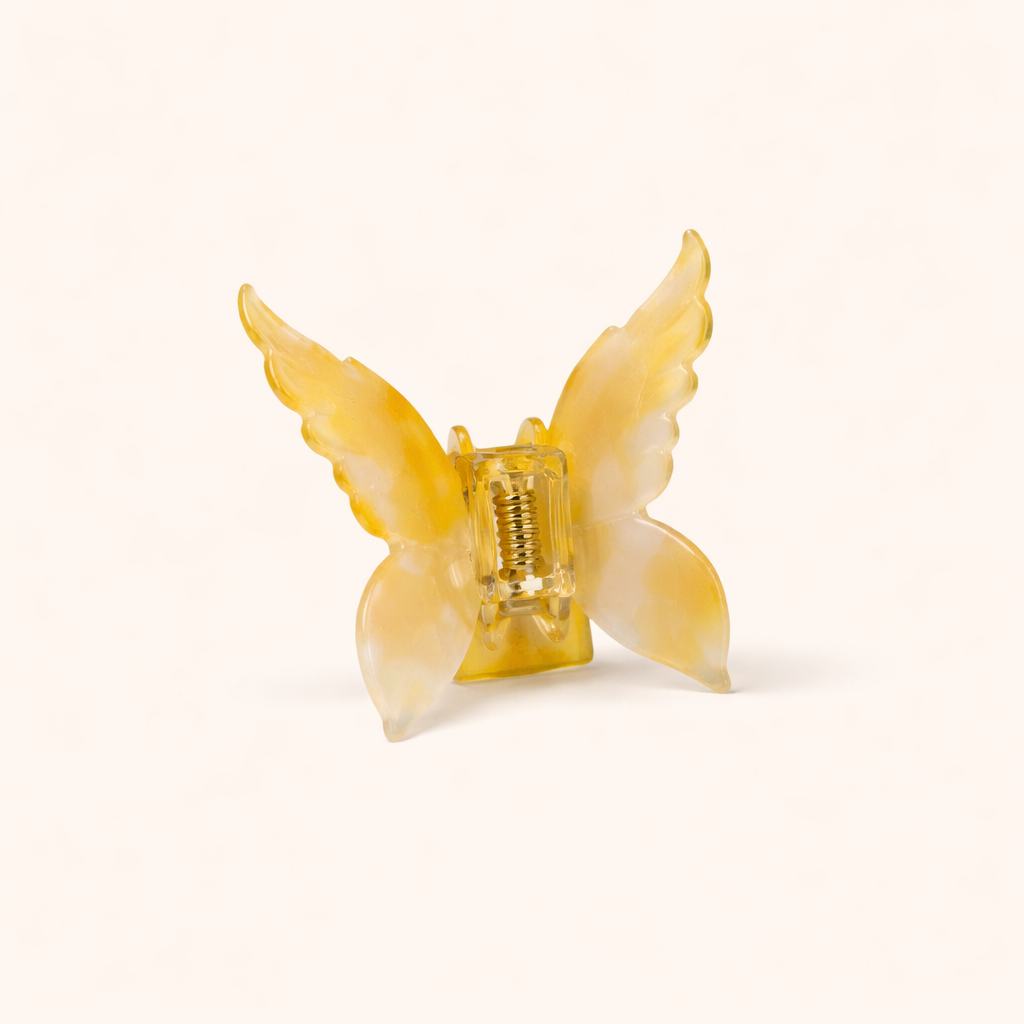 Golden amber ombré acetate butterfly-shaped claw clip from the Mariposa HAIR CLIP collection, on a cream background.