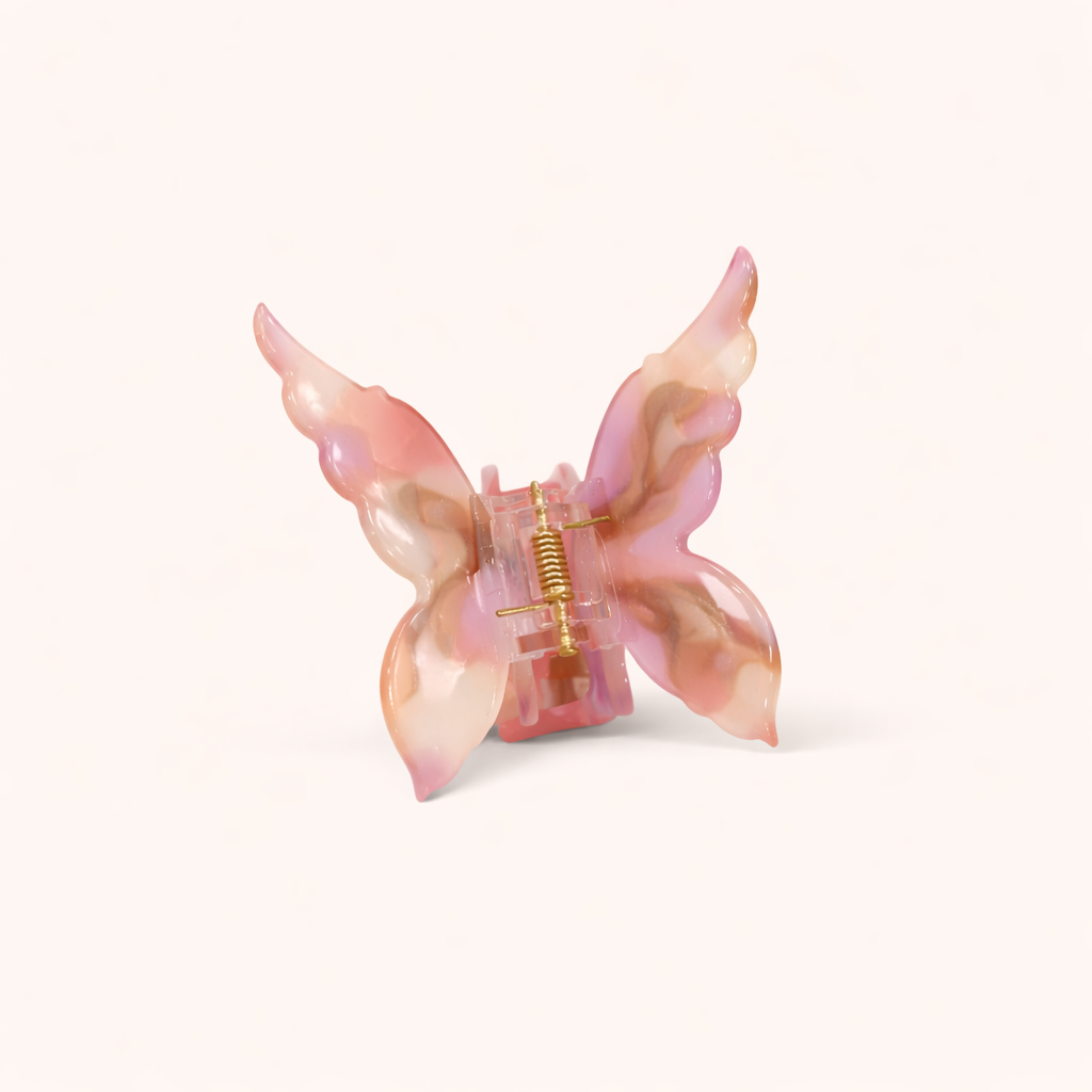 Pink and tan ombré acetate butterfly-shaped claw clip from the Mariposa HAIR CLIP collection, on a cream background.