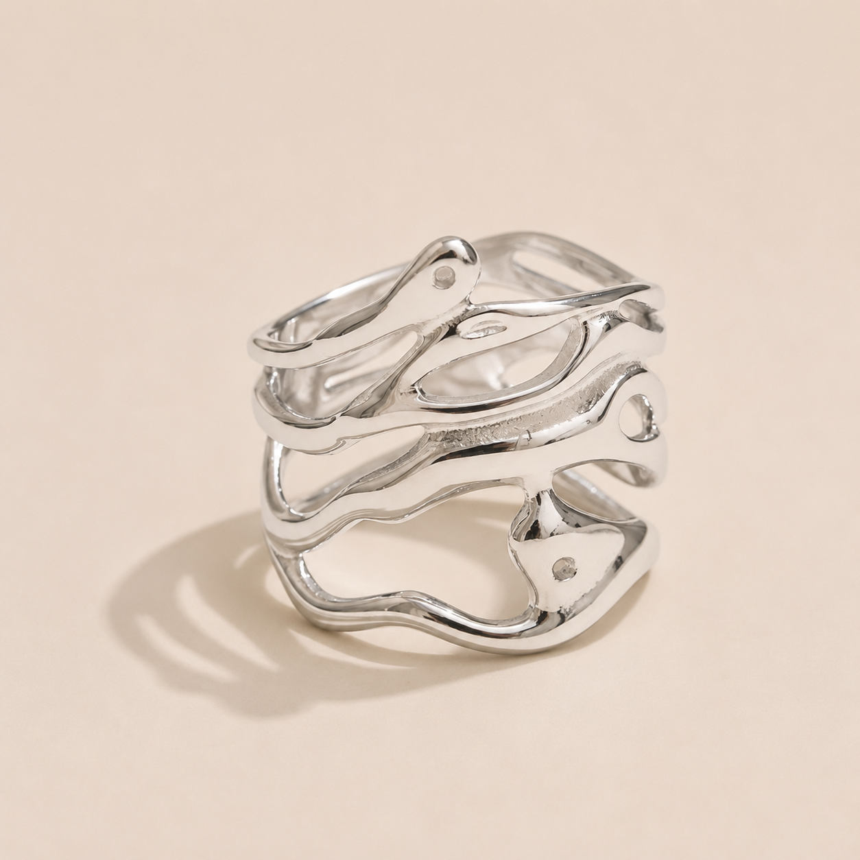 Silver wide cage ring with intertwined organic wave lines forming an open lattice, on a beige backdrop — Folie à Trois Mediterranean Muse RING.