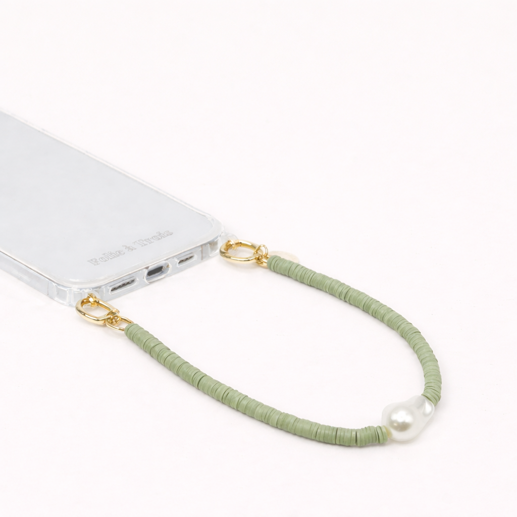 Green heishi bead Melody SHORT PHONE CORD with a baroque pearl accent, clipped to a clear phone case.