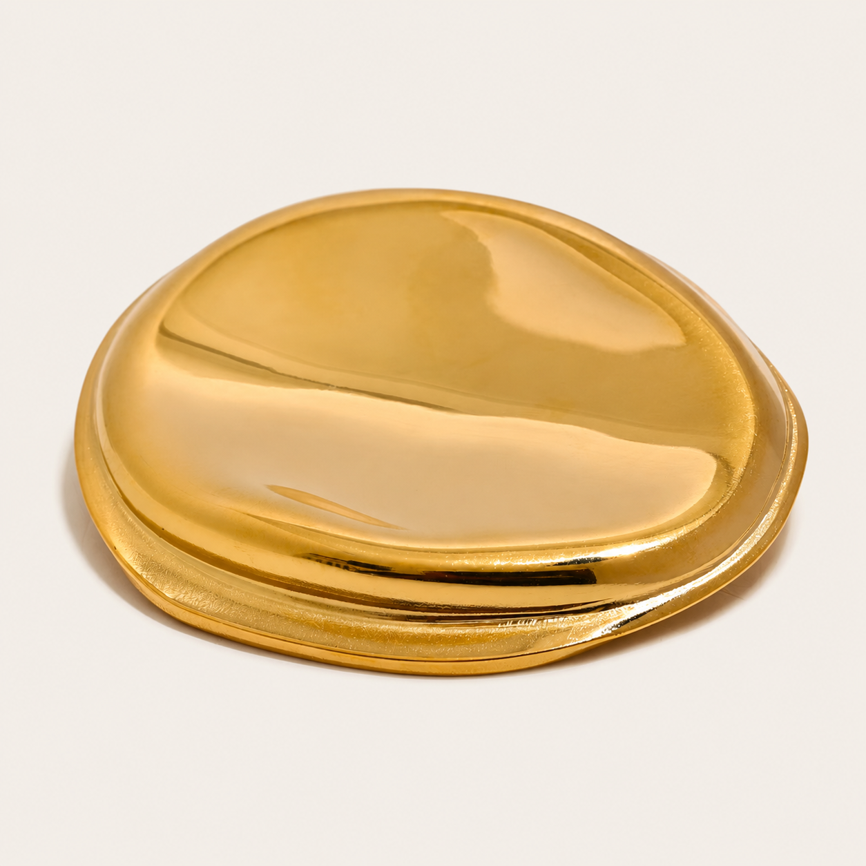 Gold molten pebble-shaped brooch with a glossy, sculptural finish on a cream backdrop — Folie à Trois Mina BROOCH.