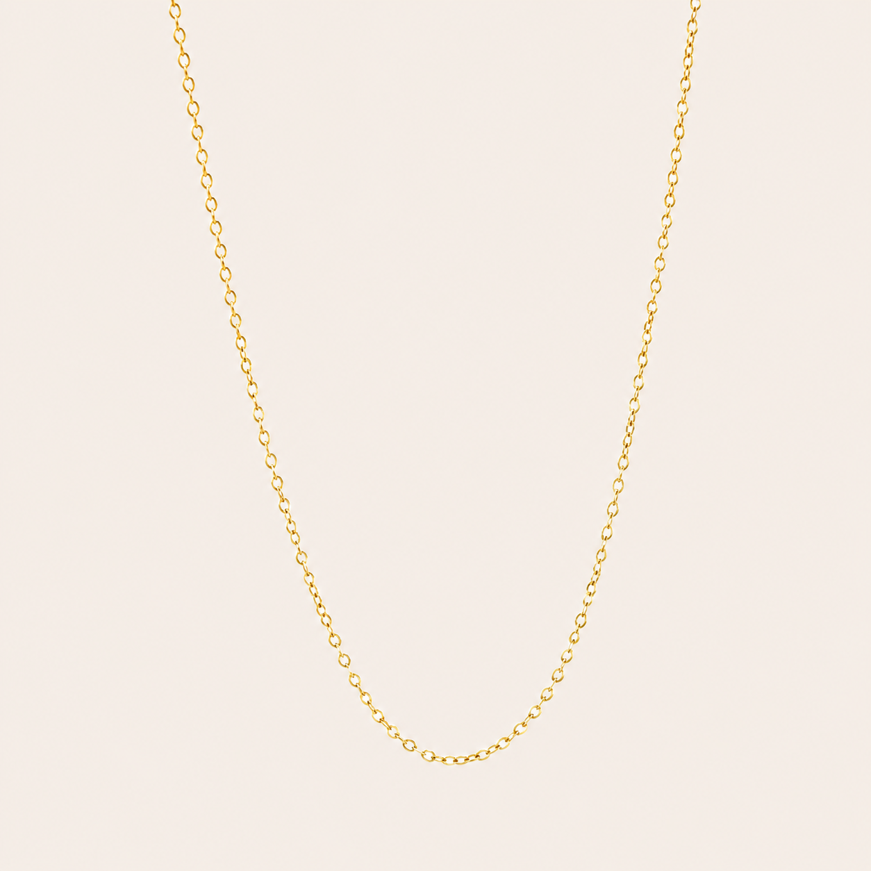 The Minimal NECKLACE in a flat lay, a fine gold cable chain shown plain with no charms on a cream background.