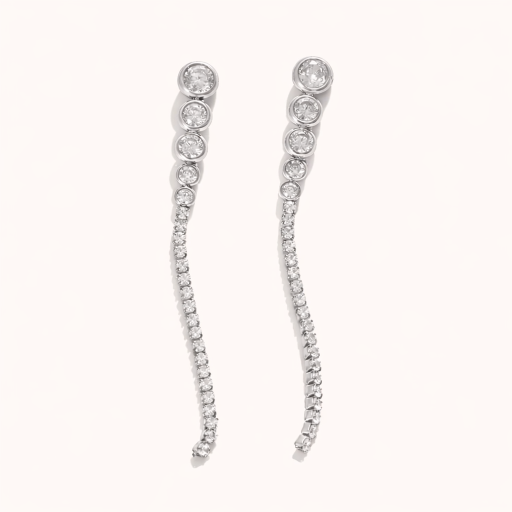 Odette Earrings trail a graduated line of round crystals from a bezel-set top stud into a delicate pave curve, in silver tone.