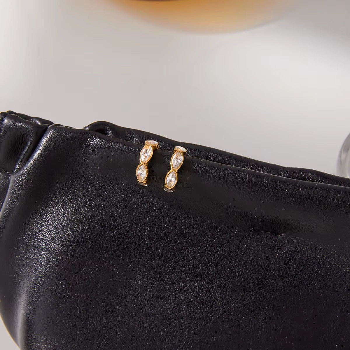 Pair of Overdrive ear cuffs on a black leather pouch, shown side-on with the marquise crystals lined vertically.
