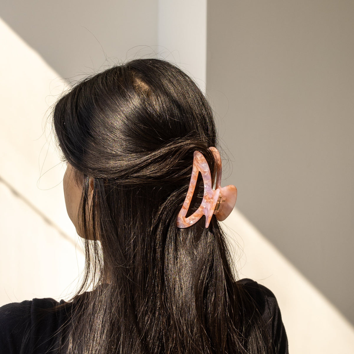 Palm Springs HAIR CLIP's pink marbled claw clip worn in half-up dark hair.