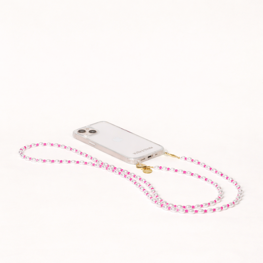 White pearl and pink bead Posy Pearl LONG PHONE STRAP attached to a clear phone case, shown as a flat lay.