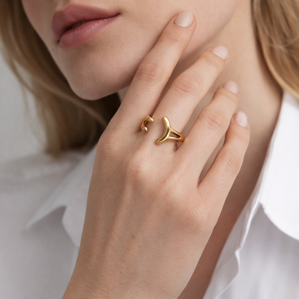 Close-up of a hand near the chin wearing the open gold branching Power Play RING stacked next to a smaller gold band.