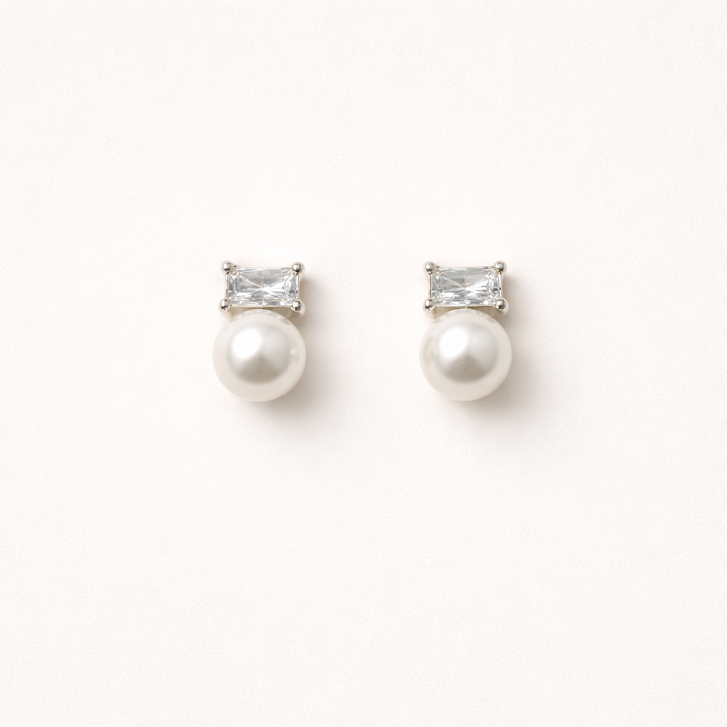 Radiant Reverie Earrings pair a clear baguette-cut stone with a round pearl below, set in polished silver.