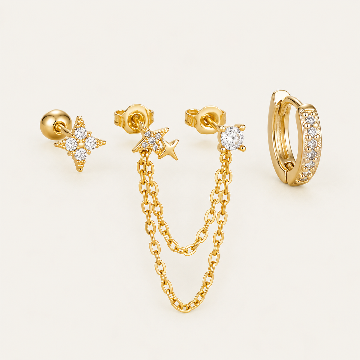 Four gold Folie à Trois Romy SET pieces: a star stud, a star chain-drop earring, a round bezel stud and a pavé huggie hoop.