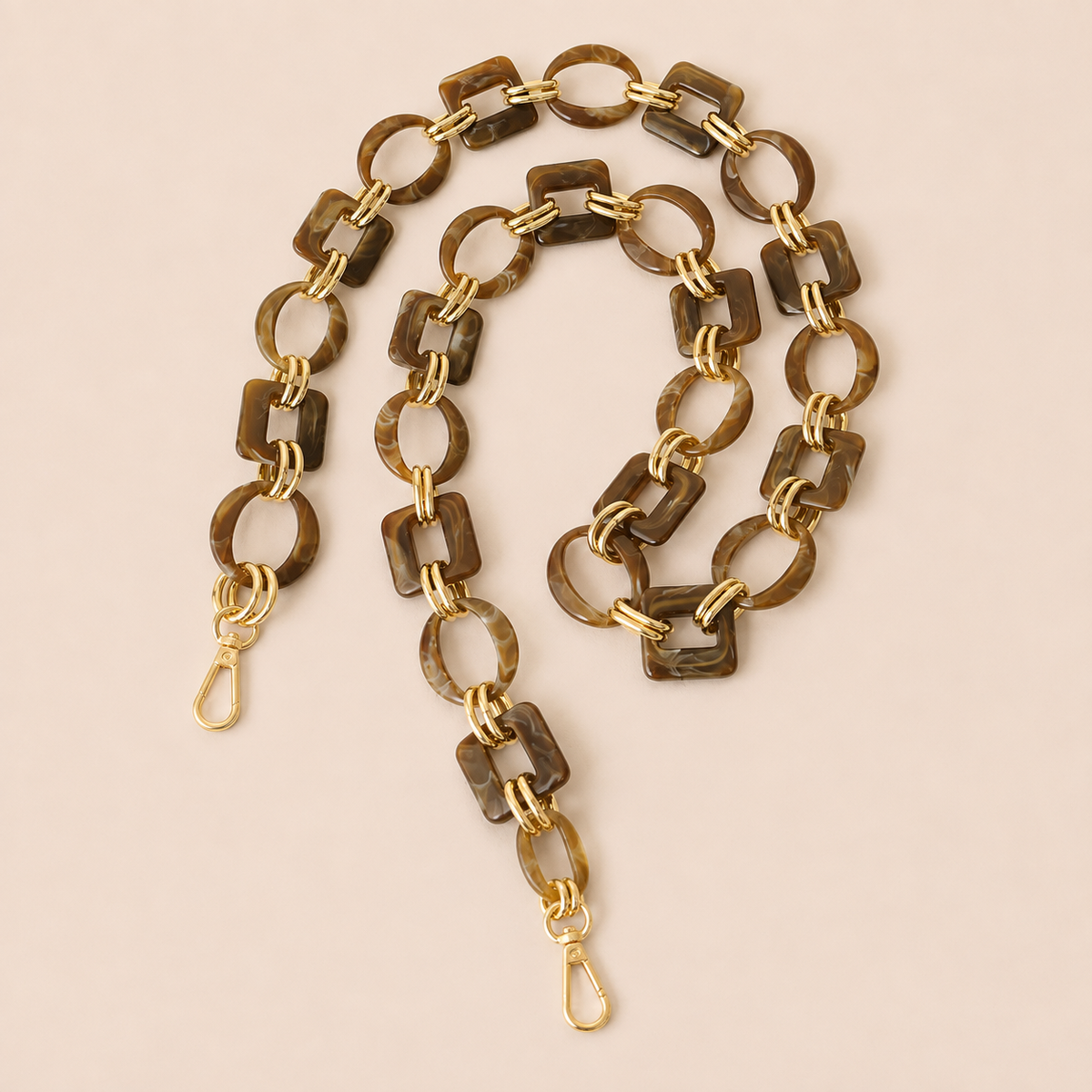 Dark brown tortoiseshell acrylic link phone chain with gold connectors coiled on cream — Folie à Trois Rowan long phone chain