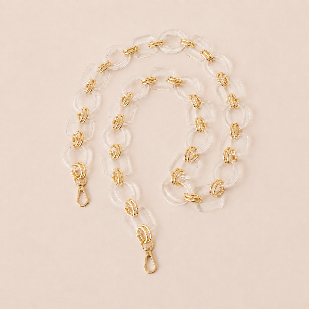 Clear acrylic link phone chain with gold connectors coiled on cream — Folie à Trois Rowan long phone chain