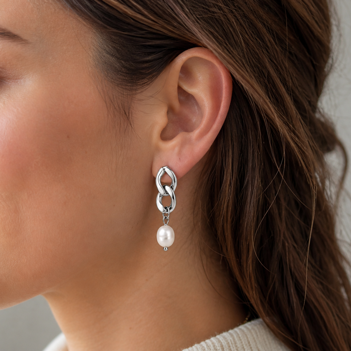 Worn along the ear, Rule Earrings show their bold silver chain links dropping down to a single lustrous pearl.
