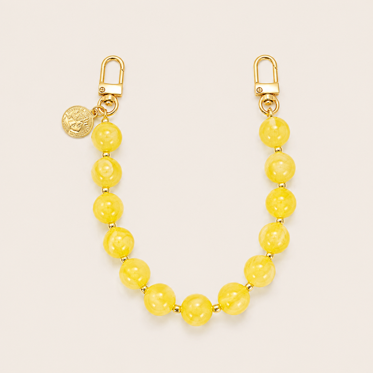 The Sable PHONE CHAIN in bright yellow beads with gold-tone spacers, clasps, and a small coin charm.