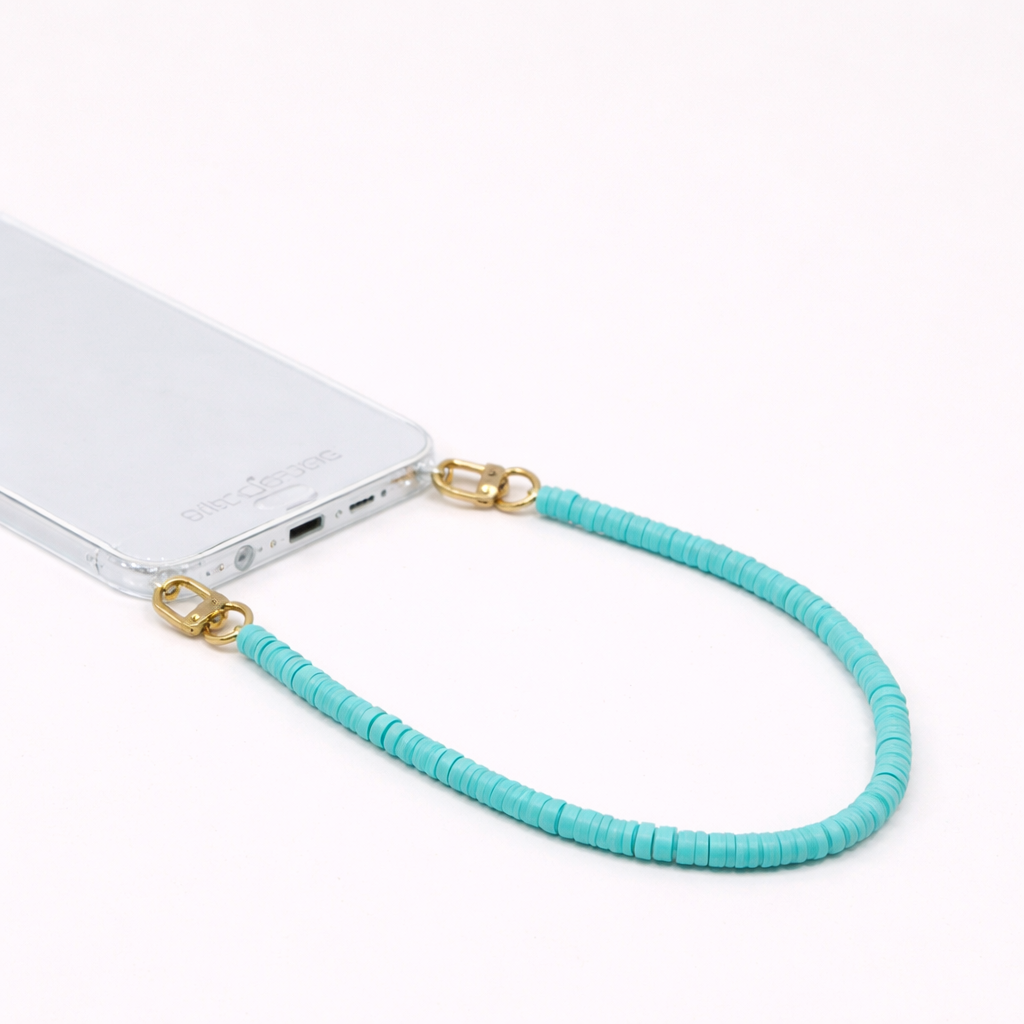 Turquoise heishi bead Scottie SHORT PHONE CORD clipped to a clear phone case with gold hardware.