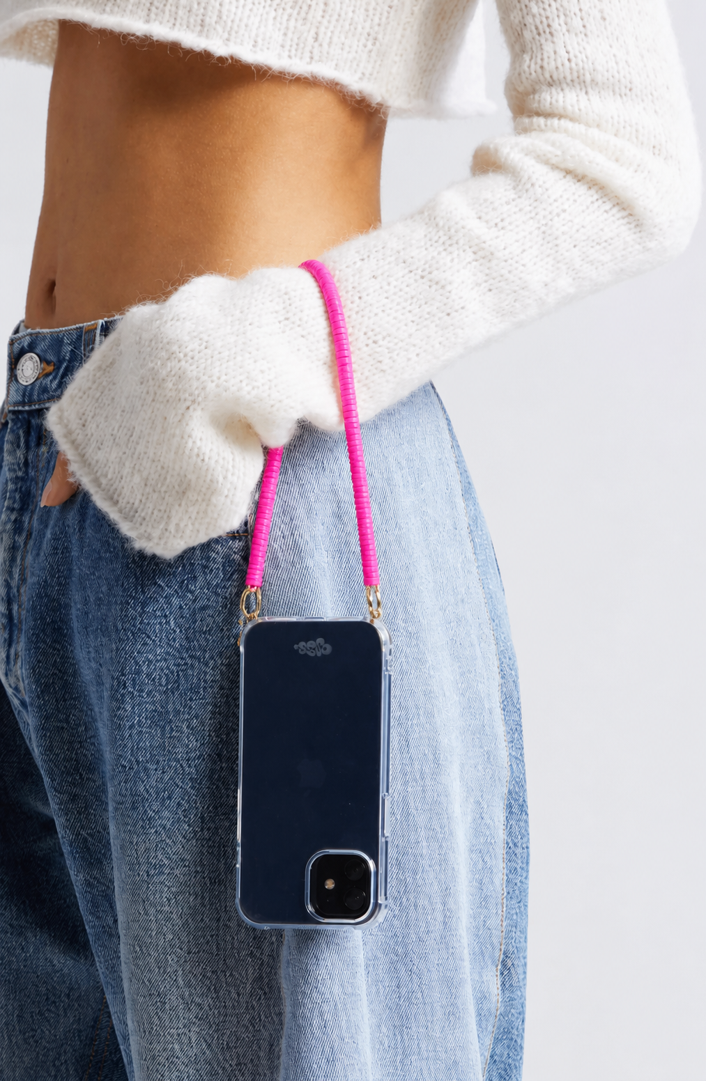 Woman holding a navy phone case attached to a hot pink heishi bead Scottie SHORT PHONE CORD.